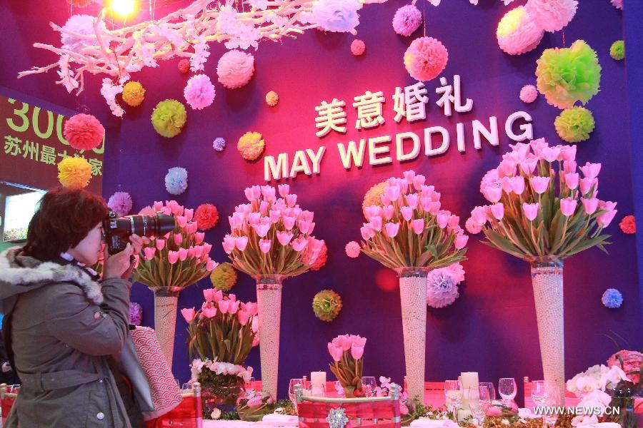 A visitor takes photos of wedding necessities during a wedding expo in Suzhou City, east China's Jiangsu Province, March 1, 2013. (Xinhua/Hang Xingwei)