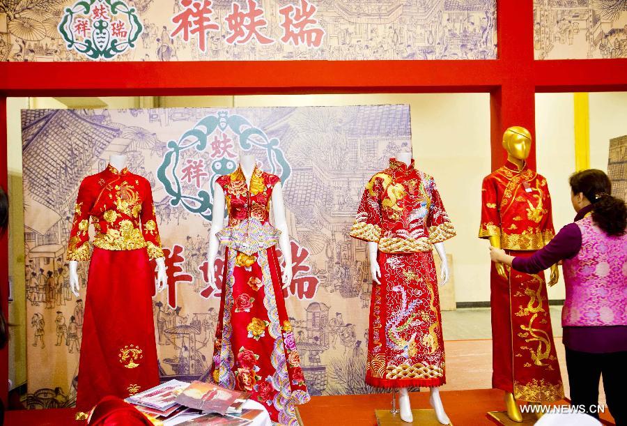 A working staff puts wedding dresses on models during the 2013 Beijing Wedding Expo in Beijing, capital of China, March 1, 2013. The three-day event kicked off on Friday. (Xinhua/Wang Jingsheng)