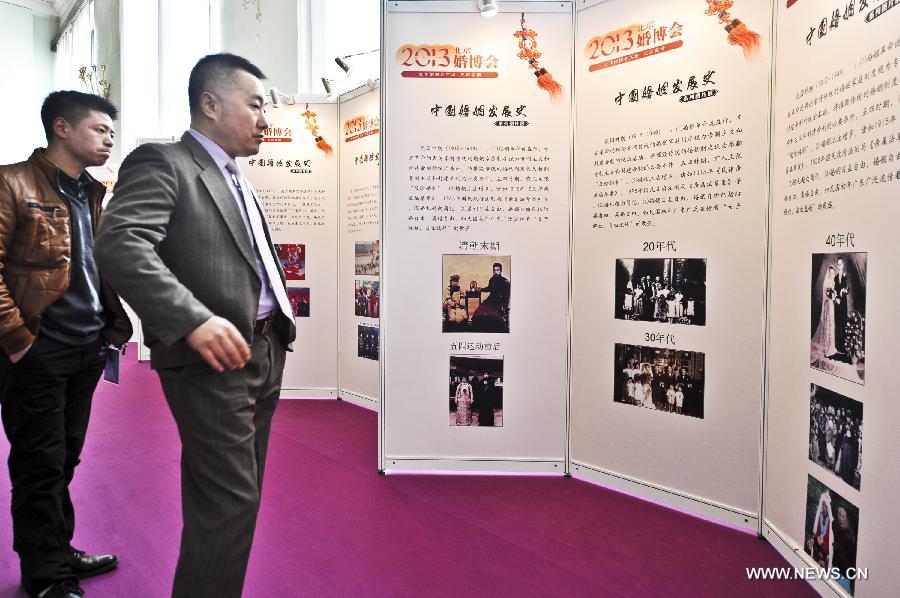 Visitors view the presentation of the development of Chinese marriage during the 2013 Beijing Wedding Expo in Beijing, capital of China, March 1, 2013. The three-day event kicked off on Friday. (Xinhua/Wang Jingsheng)