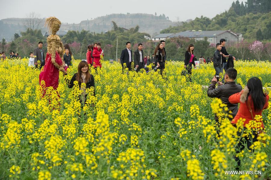 Tourists watch the rape flowers by boats during the 6th rape flower festival in Tongnan County, southwest China's Chongqing Municipality, March 1, 2013. The festival will last until late March. (Xinhua/Chen Cheng)