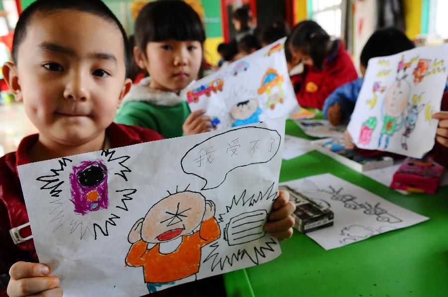 Students show her drawing about noise during an activity celebrating the upcoming Ear-care Day, which falls on March 3 every year, in Liaocheng City, east China's Shandong Province, March 1, 2013. (Xinhua/Zhang Zhenxiang)