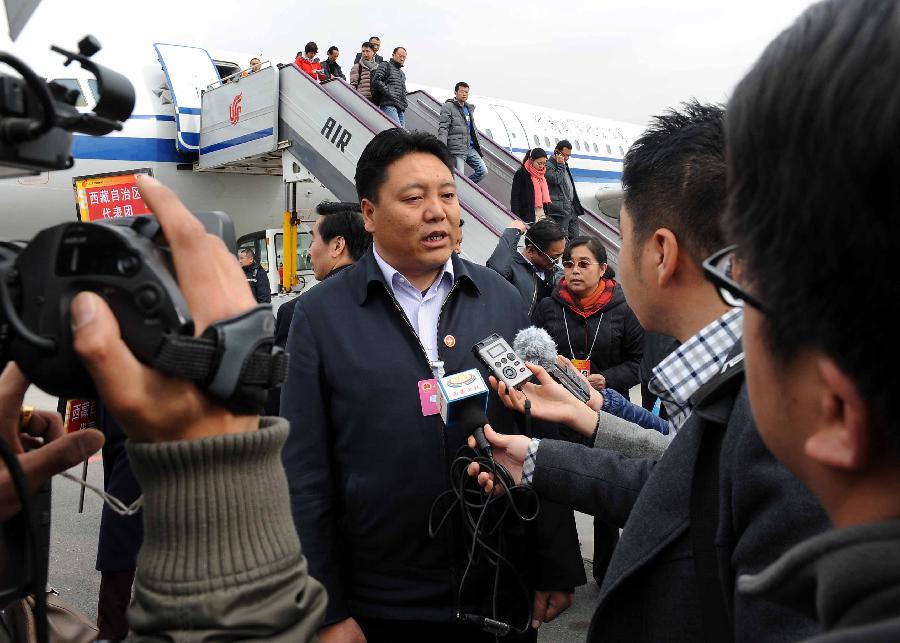 Yundan (C), a deputy to the 12th National People's Congress (NPC) from southwest China's Tibet Autonomous Region, receives an interview upon his arrival in Beijing, capital of China, March 2, 2013. The first session of the 12th NPC is scheduled to open in Beijing on March 5. (Xinhua/Wang Song)