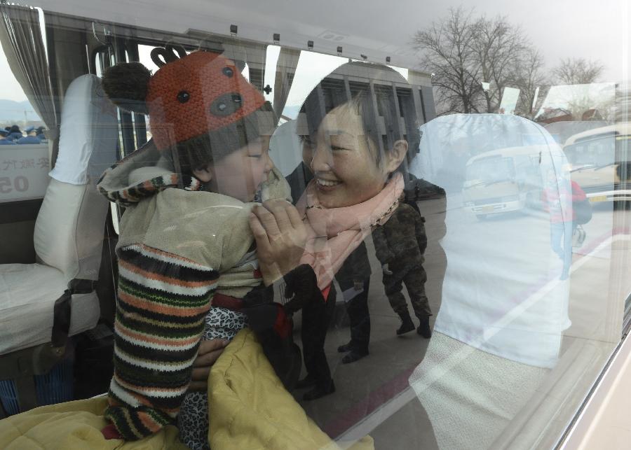 Peng Weiping, a deputy to the 12th National People's Congress (NPC) from east China's Anhui Province, is seen with her baby in a bus to the hotel after their arrival at the airport in Beijing, capital of China, March 2, 2013. The first session of 12th NPC is scheduled to open in Beijing on March 5. (Xinhua/Li Tao)