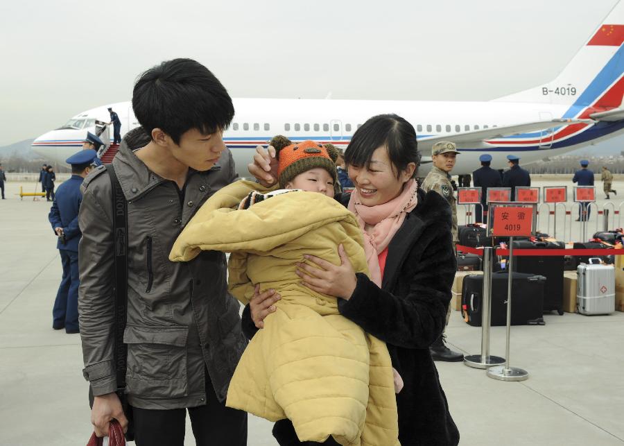 Peng Weiping (R front), a deputy to the 12th National People's Congress (NPC) from east China's Anhui Province, is seen with her baby and husband at the airport upon their arrival in Beijing, capital of China, March 2, 2013. The first session of 12th NPC is scheduled to open in Beijing on March 5. (Xinhua/Xie Huanchi)