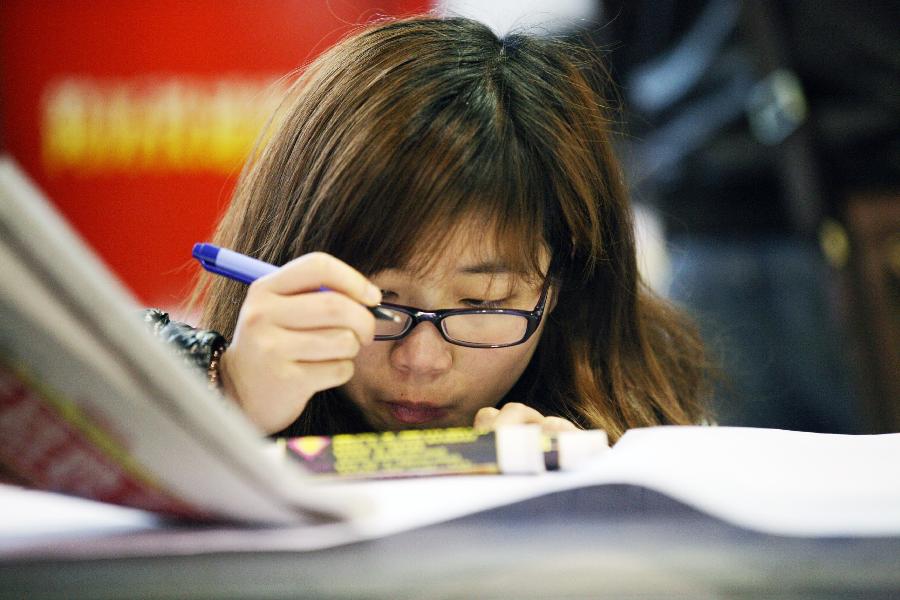 A job seeker fills her resume at a job fair in Nanjing, capital of east China's Jiangsu Province, March 2, 2013. More than 20,000 job opportunities were offered at the job fair. (Xinhua/Wang Xin)