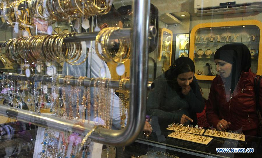 Palestinian women pick Russian gold products at a gold market in the West Bank city of Nablus on March 2, 2013. (Xinhua/Ayman Nobani)