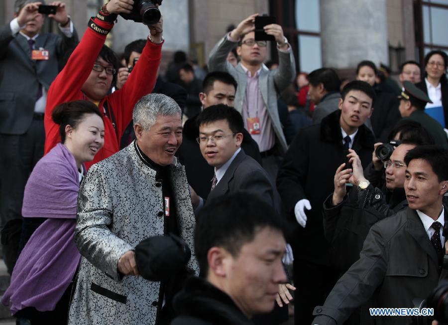 Zhao Benshan, a member of the 12th National Committee of the Chinese People's Political Consultative Conference (CPPCC), greets journalists outside the Great Hall of the People in Beijing, capital of China, March 3, 2013. The first session of the 12th CPPCC National Committee is to open on March 3. (Xinhua/Jin Liwang)