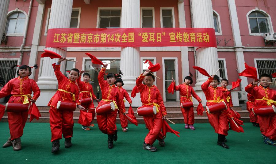 Pupils with hearing impairment perform during a public welfare activity on the Ear-care Day in Nanjing, capital of east China's Jiangsu Province, March 3, 2013. (Xinhua/Yan Minhang)