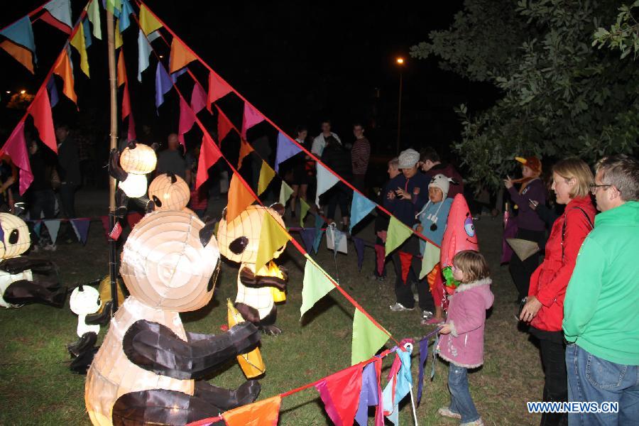 Residents watch the lanterns during the celebration of Chinese Lantern Festival in New Zealand's Christchurch, March 2, 2013. Ancient Chinese traditions mingled with contemporary folk-rock, acrobatics and kung fu tea-pouring as the 2013 Christchurch Lantern Festivals welcomed in the Year of the Snake on Saturday. (Xinhua/Huang Xingwei)