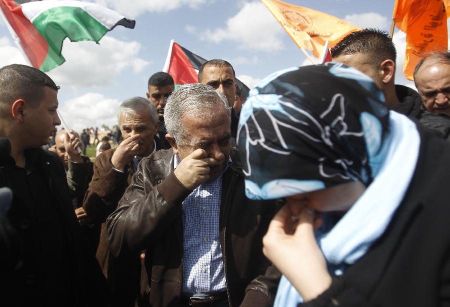 Palestinian Prime Minister Salam Fayyad (C) reacts from tear gas fired by Israeli army during a protest marking the 8th anniversary of their campaign against the controversial Israeli barrier in the West Bank village of Bilin near Ramallah March 1, 2013.  (Xinhua/Reuters Photo)