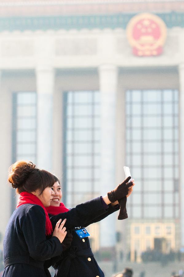 Staff members pose for a photo at the Tian'anmen Square in Beijing, capital of China, March 3, 2013. The first session of the 12th National Committee of the Chinese People's Political Consultative Conference (CPPCC) opened in Beijing on March 3. (Xinhua/Liu Jinhai) 