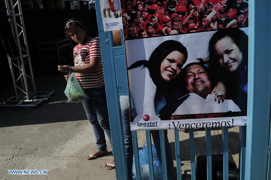 A girl stands beside a poster of Venezuelan President Hugo Chavez on a street in Caracas, capital of Venezuela, on Mar. 2, 2013. Venezuela's ailing President Hugo Chavez is undergoing chemotherapy in the capital's military hospital, Vice President Nicolas Maduro said Friday, calling for respect for Chavez and his family. (Xinhua/Mauricio Valenzuela)