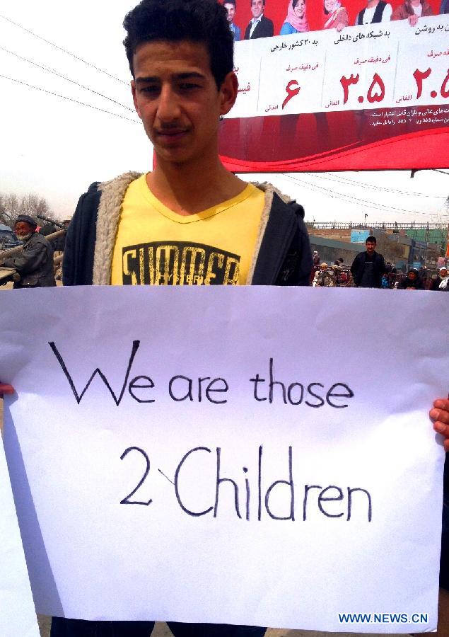 An Afghan young man carries a slogan during a protest to condemn the killing of two children by NATO forces in Kabul, March 3, 2013. Two Afghan brothers, both under seven years old, were shot dead by a NATO helicopter after being mistaken for Taliban insurgents. (Xinhua/Omid)