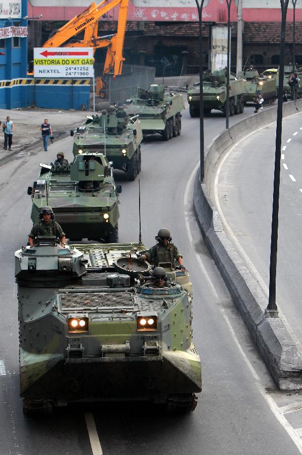 Soldiers on tanks attend to a special operation at the Caju favela in northern Rio de Janeiro, Brazil, on March 3, 2013. A thousand agents of the Civil and Military Police, 200 Navy agents and at least one helicopter took part in the operation to expel drug traffickers from the area, according to the local press. (Xinhua/AGENCIA ESTADO) 