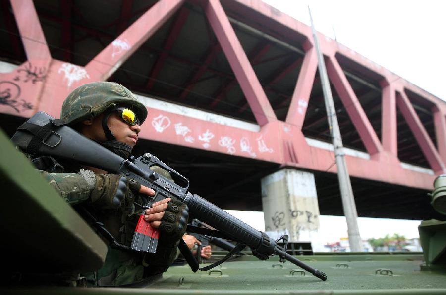 Soldiers on tanks attend a special operation at the Caju favela in northern Rio de Janeiro, Brazil, on March 3, 2013. A thousand agents of the Civil and Military Police, 200 Navy agents and at least one helicopter took part in the operation to expel drug traffickers from the area, according to the local press. (Xinhua/AGENCIA ESTADO)