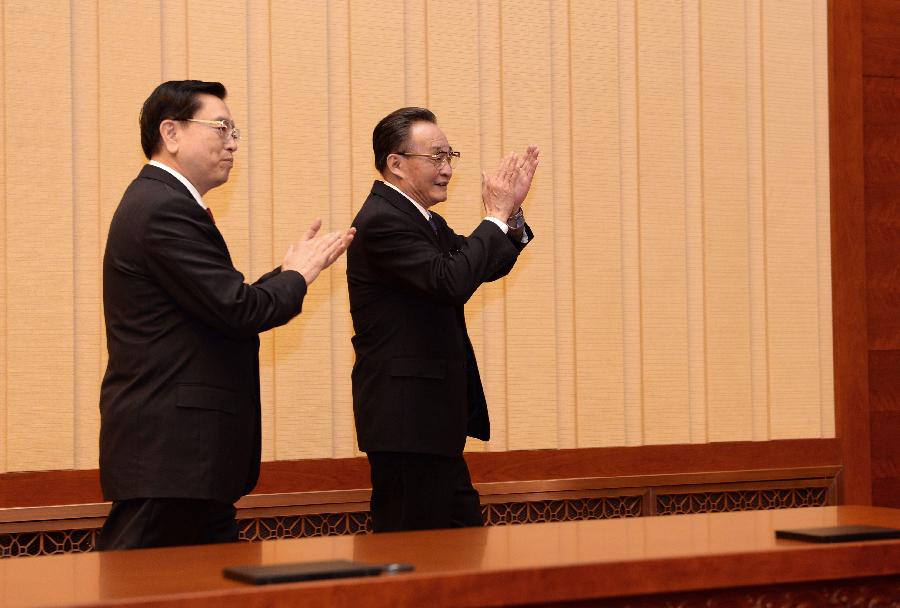 Wu Bangguo (R) and Zhang Dejiang applaud before the first meeting of the presidium of the first session of the 12th National People's Congress (NPC) at the Great Hall of the People in Beijing, capital of China, March 4, 2013. (Xinhua/Ma Zhancheng)