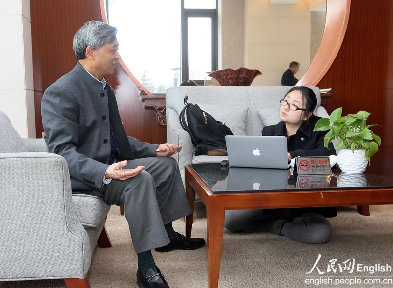 A journalist sitting on ground interviews a member of CPPCC in Beijing Convention Centre.(Photo/People's Daily Online) 