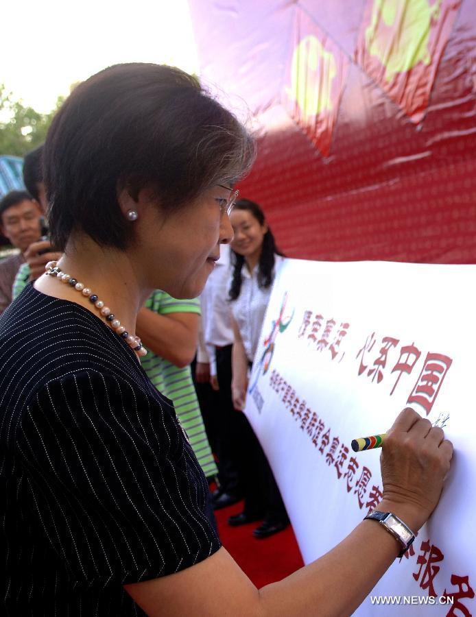 File photo taken on Feb. 28, 2007 shows Fu Ying, Chinese Ambassador to Australia, signs on a banner during an recruitment for volunteers for the Beijing Olympics in Canberra, Australia. Fu Ying debuted at the Great Hall of the People as the spokesperson for the first session of the 12th National People's Congress (NPC) in Beijing, China, March 4, 2013. Born in 1953, the spokesperson was a diplomat of Mongolian ethnic group. Fu had respectively served as the Ambassador to the Philippines, Australia and the UK before she was appointed as Vice minister of Foreign Affairs in 2009. She became the 7th spokesperson of the NPC in March of 2013. (Xinhua)