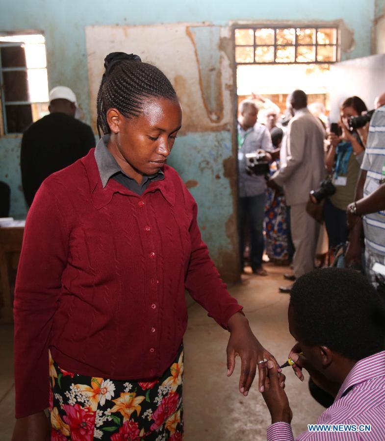 An election staff marks the hand of a voter at a polling station in Nairobi, Kenya, March 4, 2013. A total of 14.3 million Kenyan voters lined up to cast their ballots Monday morning to choose the country's next president, the first after disputed presidential elections tally stirred up violence five years ago. (Xinhua/Meng Chenguang)