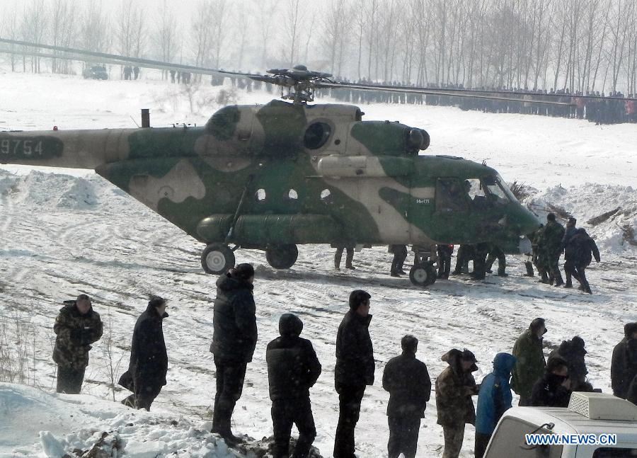 A helicopter sends trapped people to safe place near the Songhuajiang River, northeast China's Jilin Province, March 4, 2013. Nine people were evacuated to safety by a helicopter after three ferries carrying nine passengers were stranded for more than 28 hours in the Songhua River on Monday. (Xinhua)  