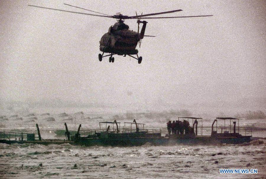 A helicopter flies to the trapped ships in the Songhuajiang River, northeast China's Jilin Province, March 4, 2013. Nine people were evacuated to safety by a helicopter after three ferries carrying nine passengers were stranded for more than 28 hours in the Songhua River on Monday. (Xinhua) 