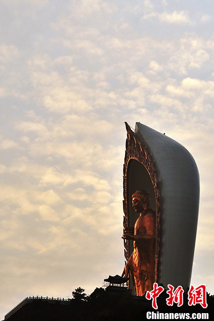 A 48-meter-high bronze statue of Amitabha Buddha is seen on the top of a hill in Xingzi County, Jiangxi Province, March 3, 2013. The gilding work of the statue is completed on Sunday. The Buddha statue has been recognized as the highest Amitabha Buddha in the world and the only outdoor Amitabha Buddha in China. A total of 48-kilogram gold has been used to gild the Statue. The overall style of the Amitabha Buddha imitates the Buddha statues in the Longmen Grottoes and it can be regarded as a fine religious art with the highest level in the modem society, according to the principal of the project. (CNS/Hu Guolin)