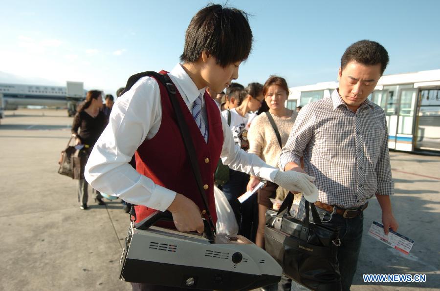 Cao Shuang, an airborne security guard of China South Air, inspects a passenger's bag at the Phoenix International Airport in Sanya, southernmost China's island province of Hainan, March 4, 2013. (Xinhua/Xu Qintao) 