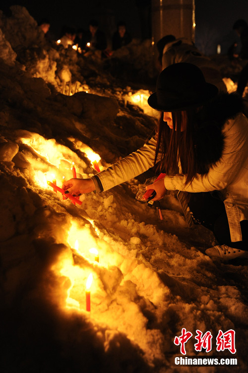 Local residents gather to mourn for the baby who was strangled to death by a car stealer in Changchun, capital of northeast China's Jilin Province, March 5, 2013. Zhou Xijun, 48, native of the Gongzhuling City of Jilin, stole a gray Toyota RAV4 SUV on March 4 in Changchun. Zhou drove the jeep on the highway and found a baby on the backseat. He parked the jeep on the roadside and then strangled the baby. (Photo/Chinanews.com)