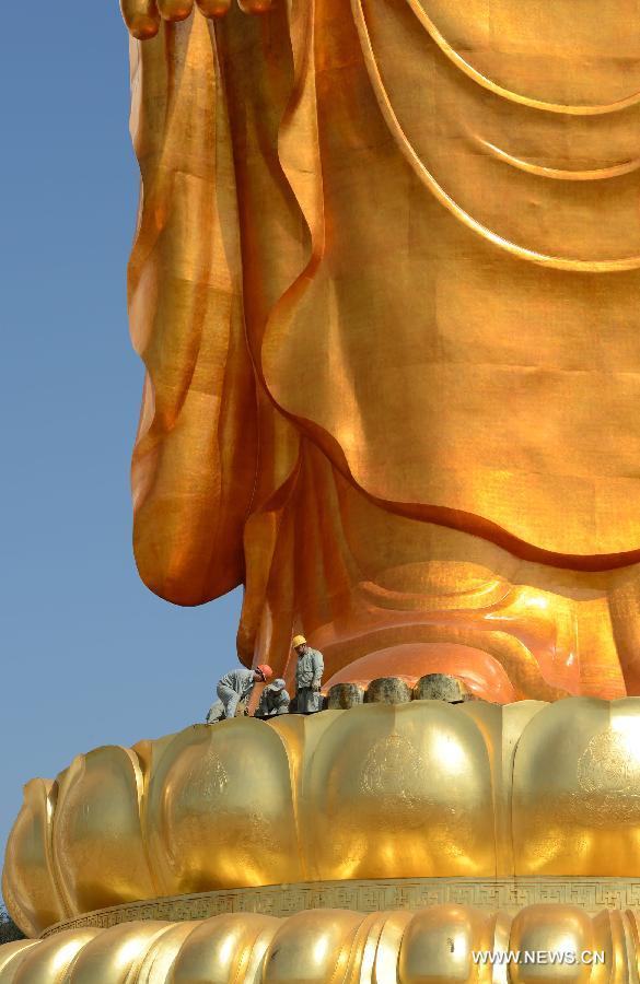 Workers plate gold for the Donglin Buddha statue at the Donglin Temple in Xingzi County of Jiujiang City, east China's Jiangxi Province, March 6, 2013. The bronze statue of Amitabha Buddha, which is 48 meters in height, is believed to be the tallest of its kind in the world. The project, with the total cost of about 1 billion yuan (161 million U.S. dollars), has been basically completed. It was totally funded by private donations. (Xinhua/Song Zhenping)  