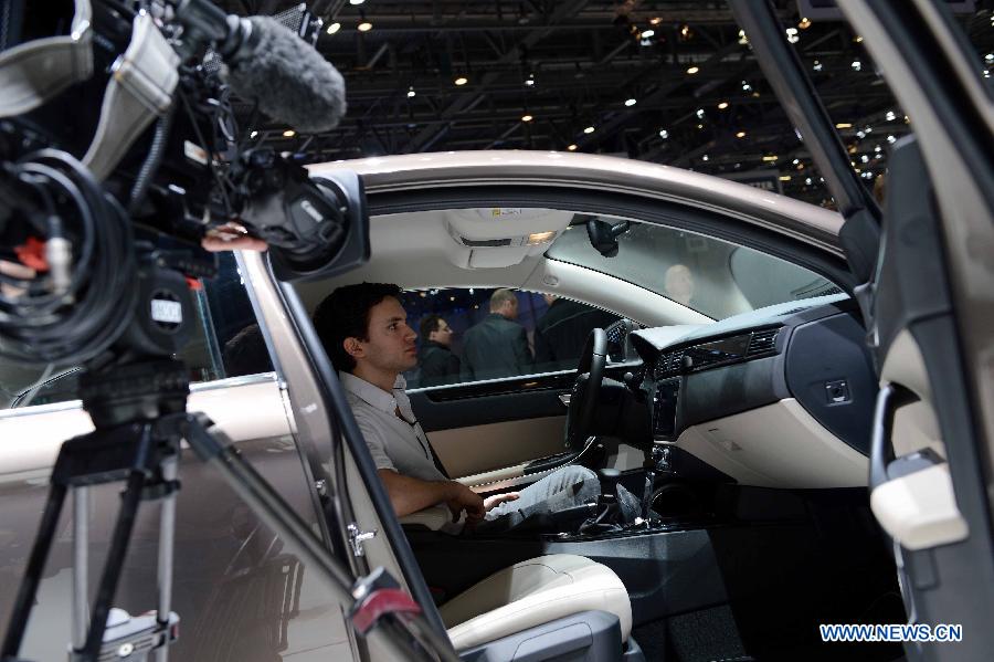 A visitor tries the Qoros 3 sedan on the press day of the 83rd Geneva International Motor Show in Geneva, Switzerland, on March 6, 2013. (Xinhua/Wang Siwei) 