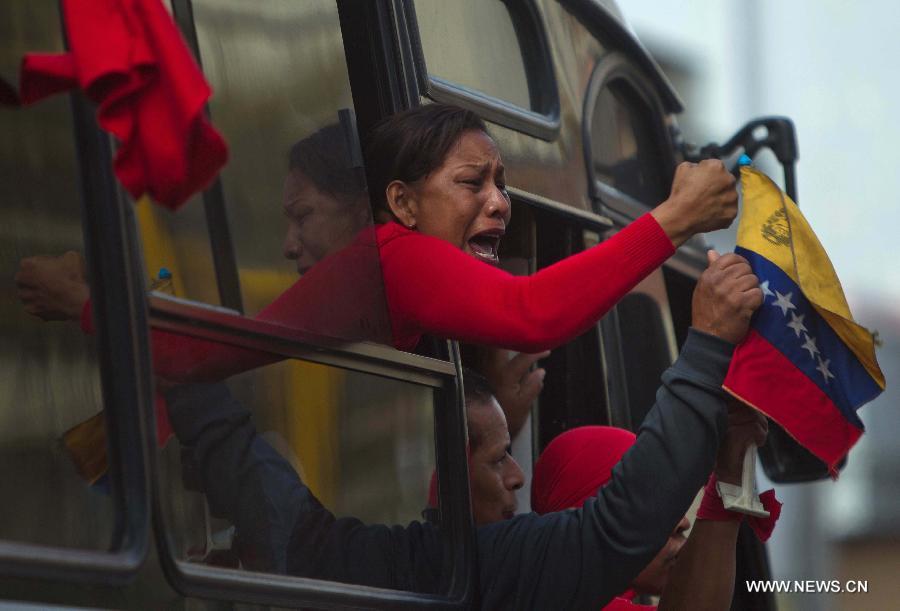 A woman reacts as she participates in the funeral procession in honor of Venezuelan President Hugo Chavez on the streets of Caracas city, capital of Venezuela, on March 6, 2013. On Tuesday afternoon, Venezuelan President, Hugo Chavez, died after fighting for almost two years with a cancer disease. The body of Chavez is moved from the health center to the Military Academy in southern Caracas, inside Tiuna's Fort. (Xinhua/David de la Paz)