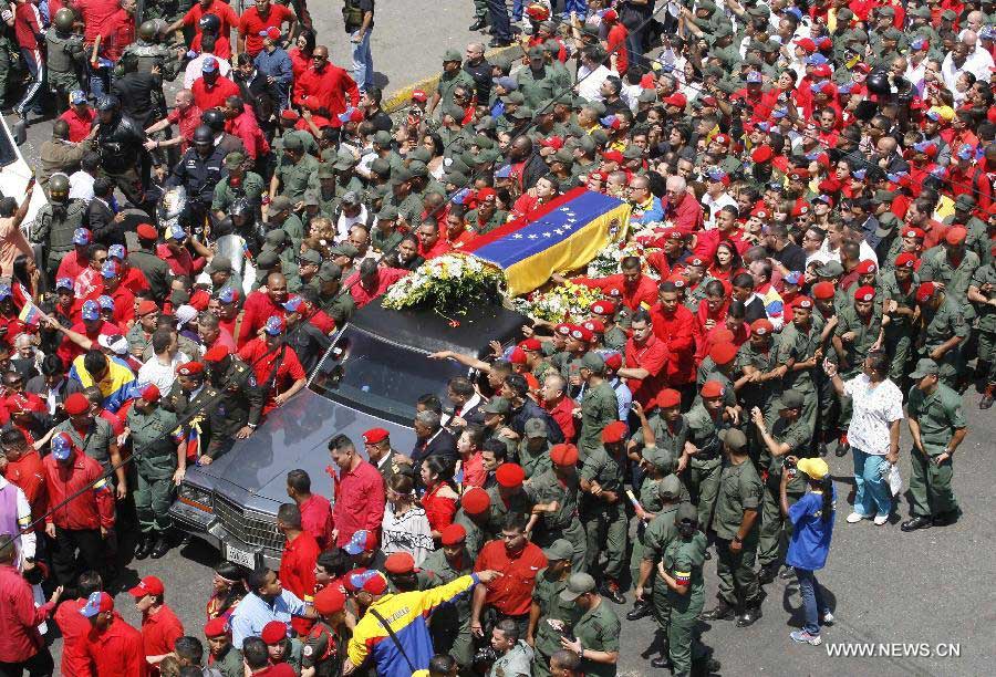 Members of the military escort Venezuelan National Guard hold a security fence during the funeral procession in honor of Venezuelan President Hugo Chavez on the streets of Caracas, capital of Venezuela, on March 6, 2013. On Tuesday afternoon, Venezuelan President, Hugo Chavez, died after fighting for almost two years with a cancer disease. The body of Chavez is moved from the health center to the Military Academy in southern Caracas, inside Tiuna's Fort. (Xinhua/Juan Carlos Hernandez)