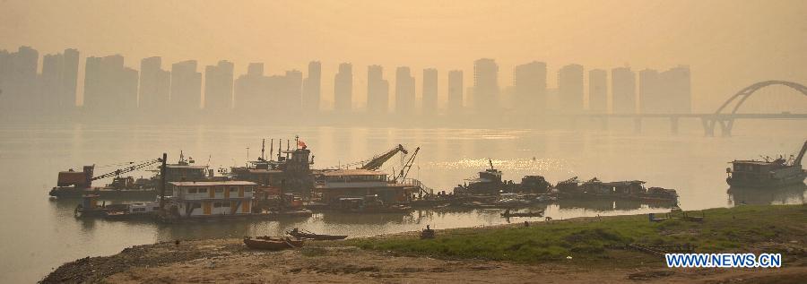 Photo taken on March 7, 2013 shows buildings along the local section of the Xiangjiang River in fog-shrouded Changsha, capital of central China's Hunan Province. (Xinhua/Long Hongtao)