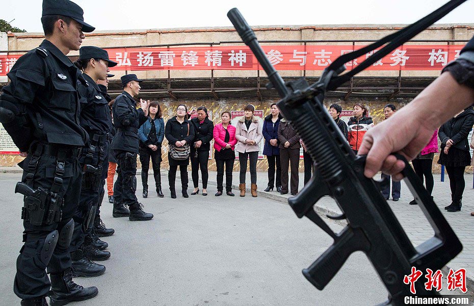 Members of Special Police unit of Huaibei Public Security Bureau in eastern China’s Anhui province demonstrate self-defense skills for local female workers with the hope of improving their awareness and ability of self-protection, March 6, 2013. (Chinanews.com/Han Suyuan) 