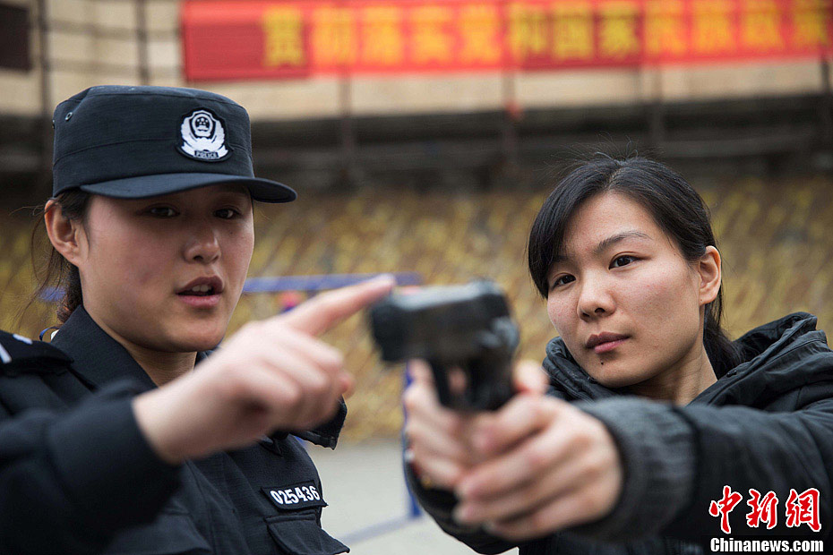 Members of Special Police unit of Huaibei Public Security Bureau in eastern China’s Anhui province demonstrate self-defense skills for local female workers with the hope of improving their awareness and ability of self-protection, March 6, 2013. (Chinanews.com/Han Suyuan) 