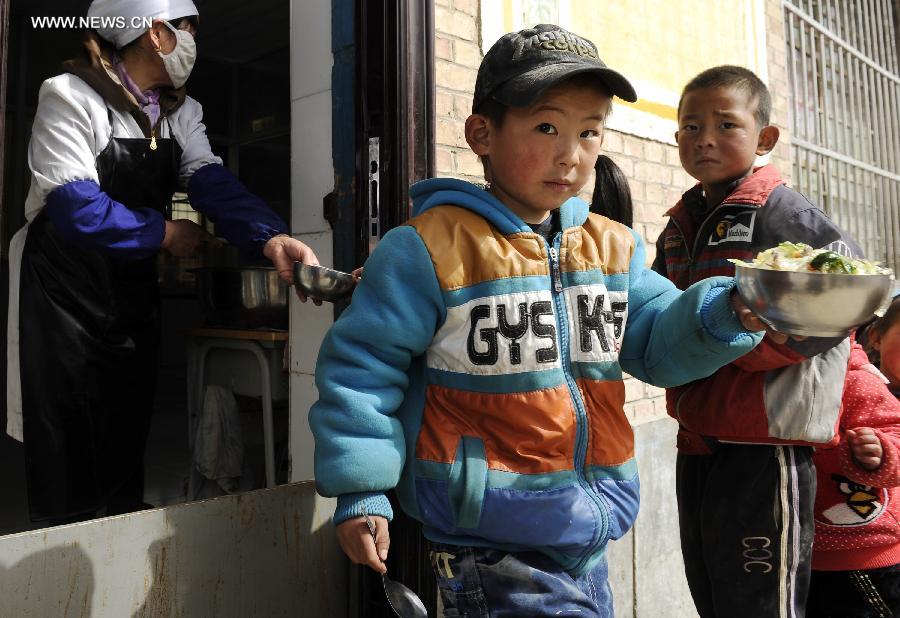 Pupils queque up to get their lunch at Dabao Primary School in Hongyao Township of Xiji County, northwest China's Ningxia Hui Autonomous Region, March 6, 2013. (Xinhua/Li Ran)