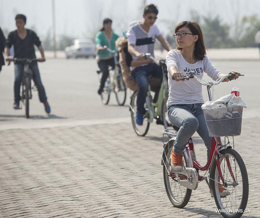 People ride on Nanbin street in Chongqing Municipality, southwest China, March 7, 2013. The highest temperature rose to 28 degrees Celsius in Chongqing on Thursday. (Xinhua/Chen Cheng)