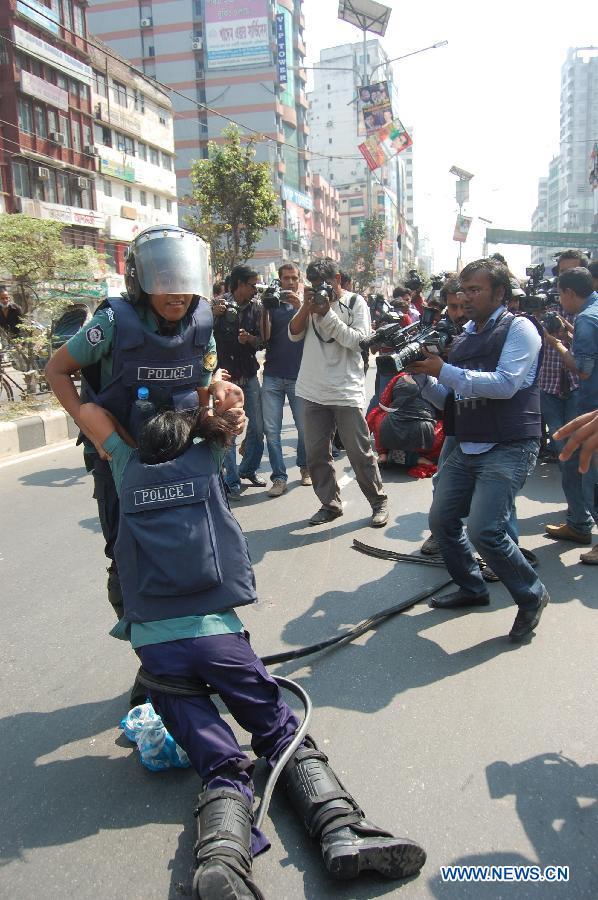 A policewoman moves her injured colleague during a countrywide general strike in Dhaka, capital of Bangladesh, March 7, 2013. Bangladesh Nationalist Party (BNP) and its alliance called the daylong countrywide strike to protest after their previous rally fizzled out amidst clashes and bomb explosions.(Xinhua/Shariful Islam)
