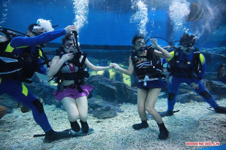 Local citizen Wang Fang dives under professional guidance to enjoy a special Women's Day at the Polar Ocean World of Wuhan, capital of central China's Hubei Province, March 8, 2013. (Xinhua/Wang Zhenwu)