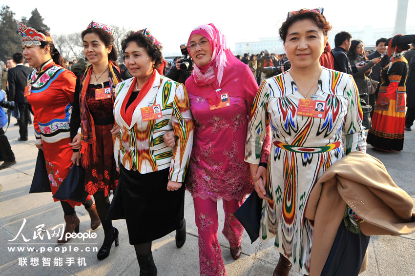 Ethnic minority deputies wearing traditional costumes take part in a panel discussion of Xinjiang delegation during the first session of the 12th NPC at the Great Hall of the People in Beijing, capital of China, March 5, 2013. (People's Daily Online/Weng Qiyu)