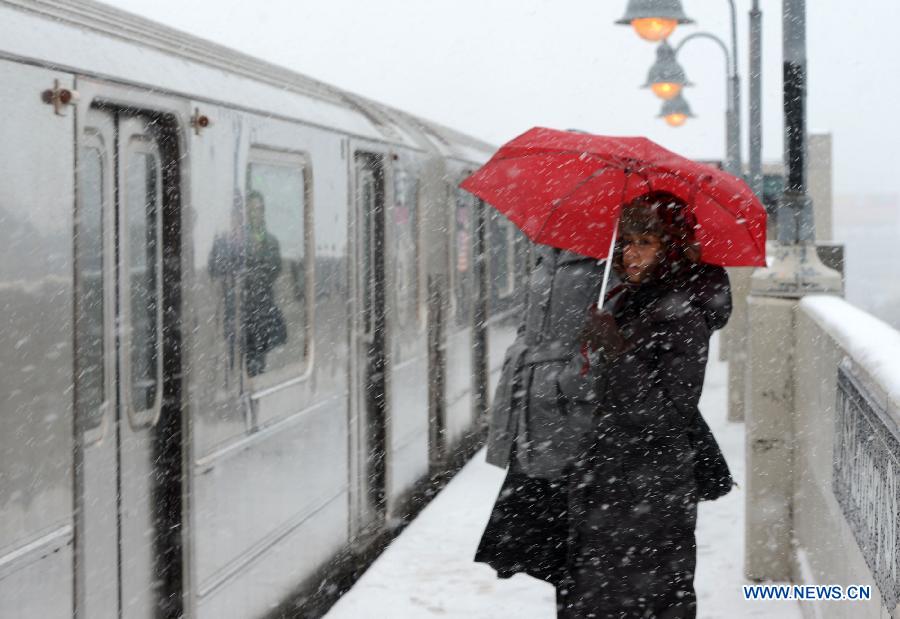 A woman waits for train amid snow at Queens borough in New York, the United States, March 8, 2013. A late winter snowstorm hit New York on Wednesday. (Xinhua/Wang Lei) 