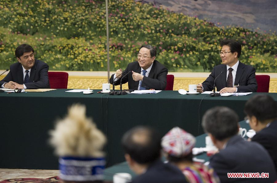 Yu Zhengsheng (C), a member of the Standing Committee of the Political Bureau of the Communist Party of China (CPC) Central Committee, joins a discussion with deputies from northwest China's Xinjiang Uygur Autonomous Region, who attend the first session of the 12th National People's Congress (NPC), in Beijing, capital of China, March 9, 2013. (Xinhua/Huang Jingwen)