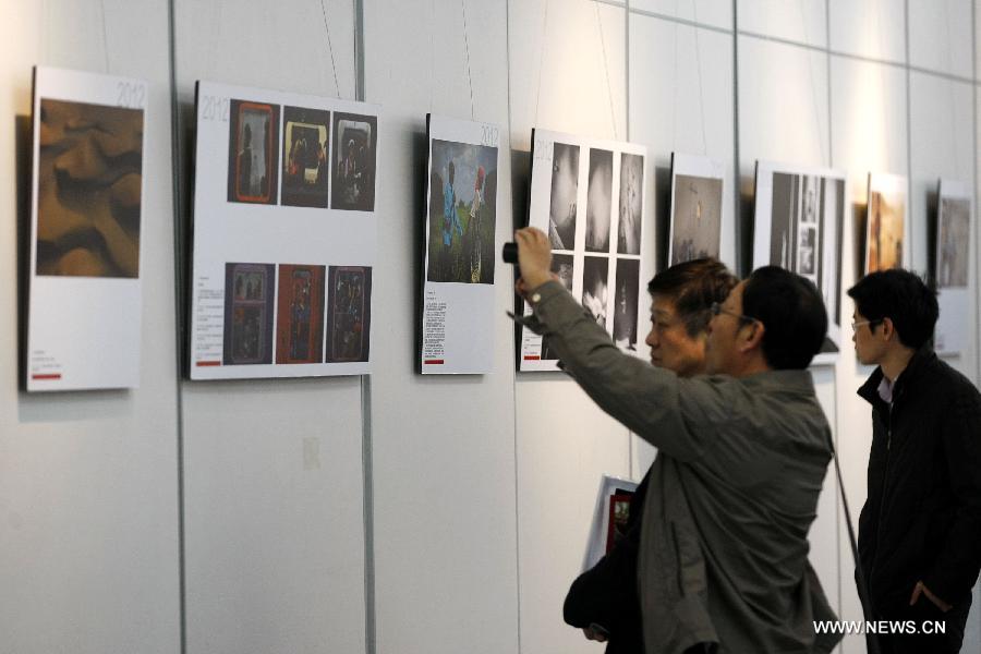 People visit a tour exhibition of the winning images of China International Press Photo Contest in the past years at the Wuxi Museum in Wuxi, east China's Jiangsu Province, March 9, 2013. (Xinhua/Sheng Guoping)