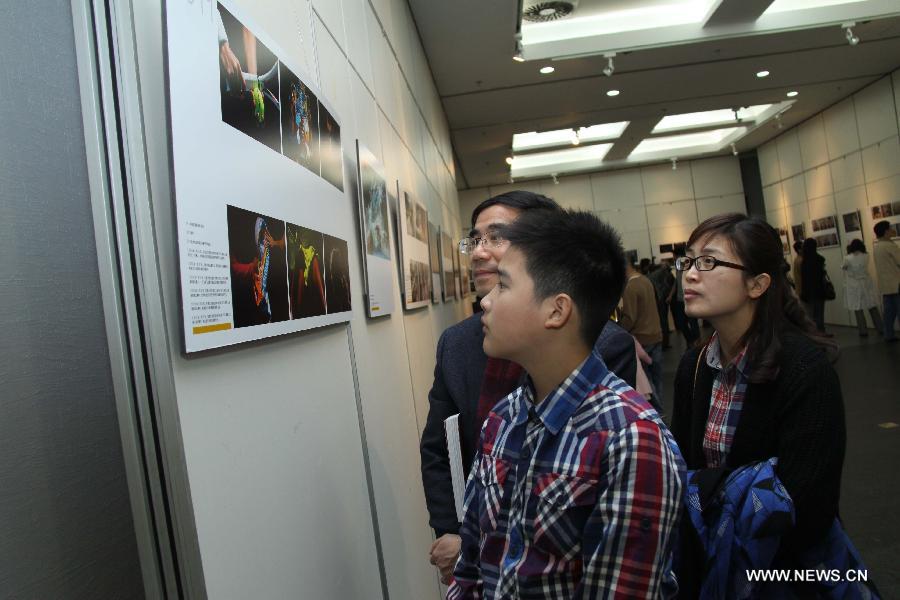 People visit a tour exhibition of the winning images of China International Press Photo Contest in the past years at the Wuxi Museum in Wuxi, east China's Jiangsu Province, March 9, 2013. (Xinhua/Sheng Guoping)