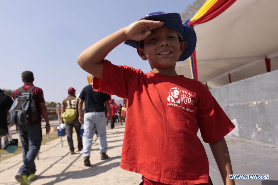 A boy waits in the Proceres Avenue to enter the Military Academy of Venezuela to say his last goodbye to President Hugo Chavez, in the city of Caracas, capital of Venezuela, on March 9, 2013. (Xinhua/AVN) 