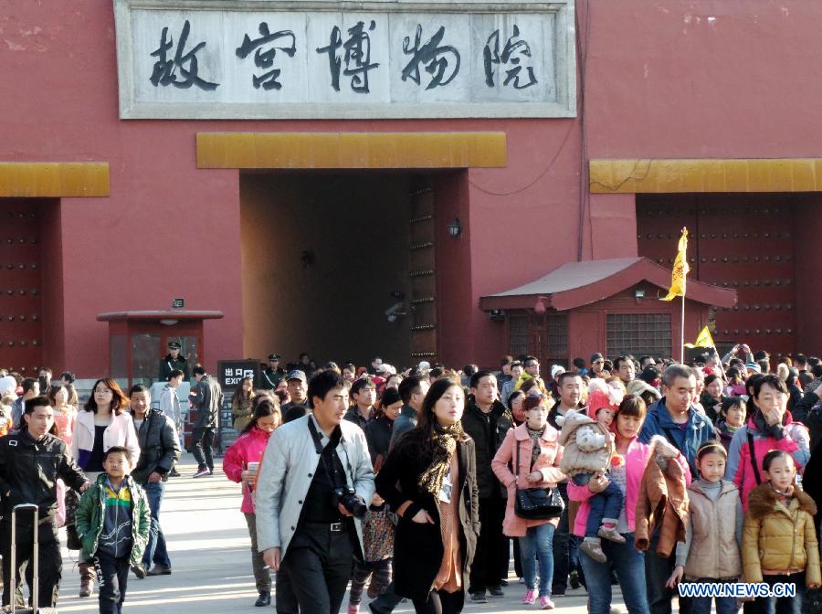 Tourists walk out of the Forbidden City in Beijing, capital of China, March 10, 2013. As the weather turned warmer, many tourists from both home and abroad came to Beijing to visit. (Xinhua/Li Xin)  