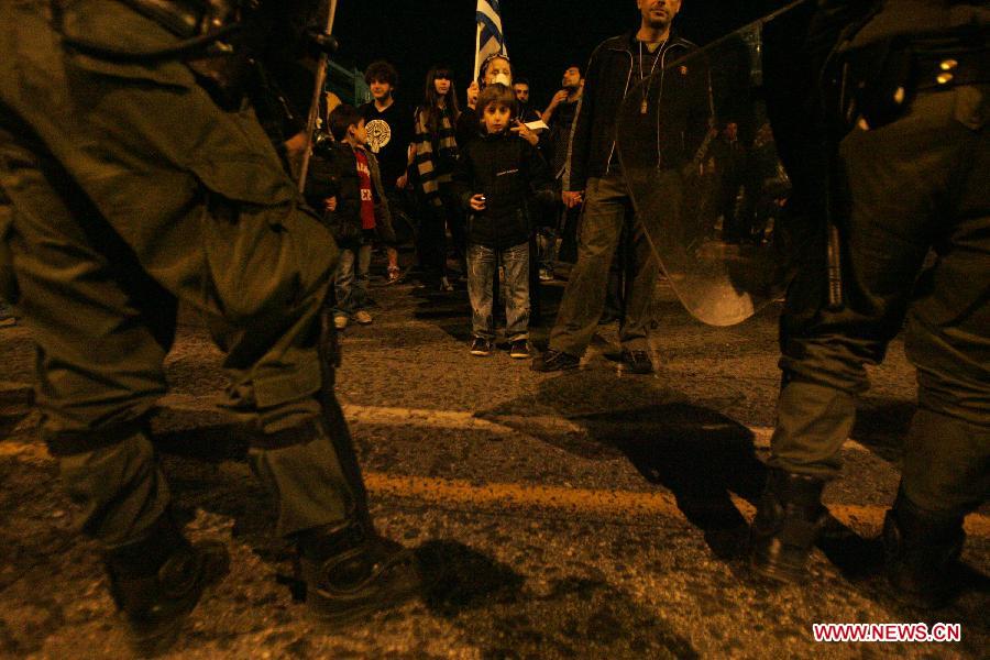 Greek indignant protesters clash with riot police in front of the Parliament in the Greek capital of Athens on March 10, 2013. About 500 indignant protesters come to Syntagma square to protest the harsh and painful austerity measures carried out by the government to counter debt crisis. (Xinhua/Marios Lolos) 