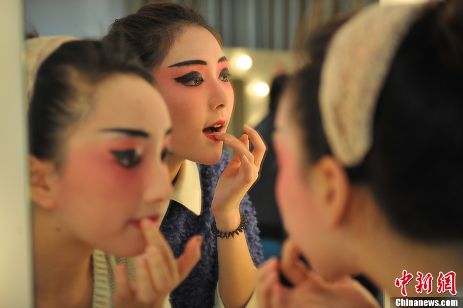 Photo shows the backstage of Gan Opera “Four Dreams in Linchuan”. Female performers are busying putting on make-up and preparing for the performance. (Photo source: chinanews.com)