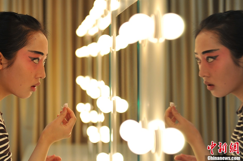 Photo shows the backstage of Gan Opera “Four Dreams in Linchuan”. Female performers are busying putting on make-up and preparing for the performance. (Photo source: chinanews.com)