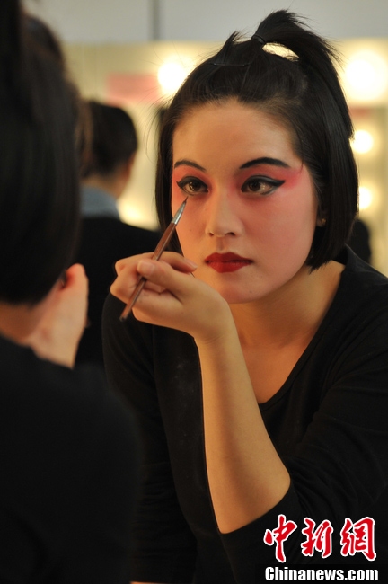 Photo shows the backstage of Gan Opera “Four Dreams in Linchuan”. Female performers are busying putting on make-up and preparing for the performance. (Photo source: chinanews.com)